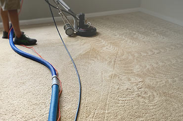 A technician using a Rotovac machine for deep residential carpet cleaning