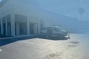 Van parked with hoses extended into the warehouse office for carpet cleaning